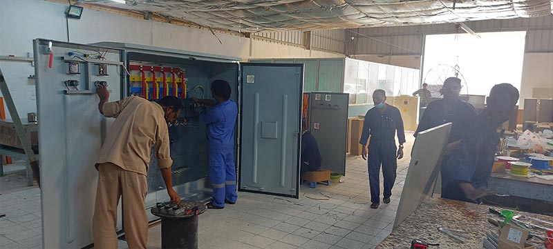 Group of engineers and technicians working on electrical panels at Ocean Wind Switchgear facility in Muscat